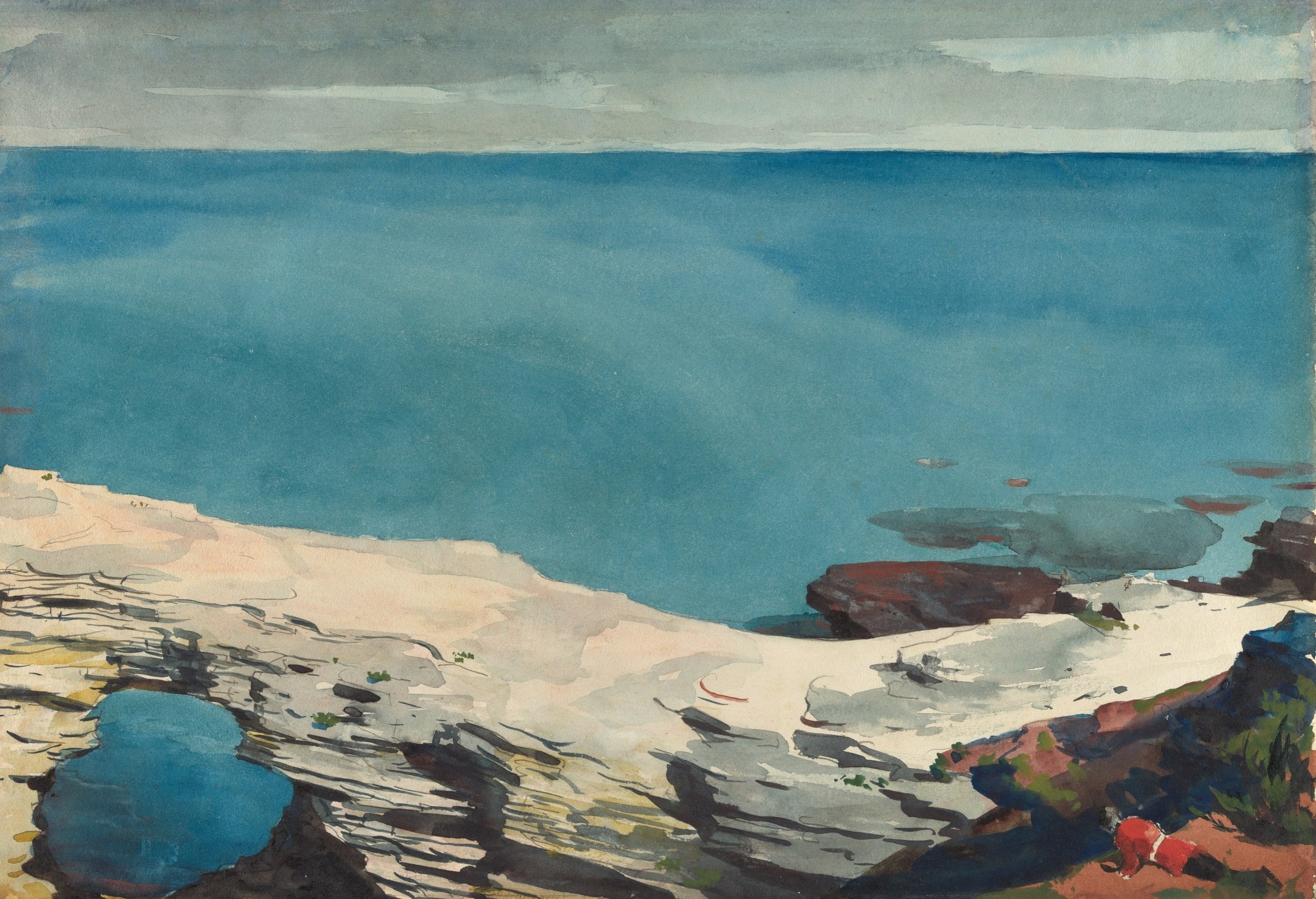 A calm turquoise bay seen from a pale limestone ledge with a small rock pool and a natural arch.